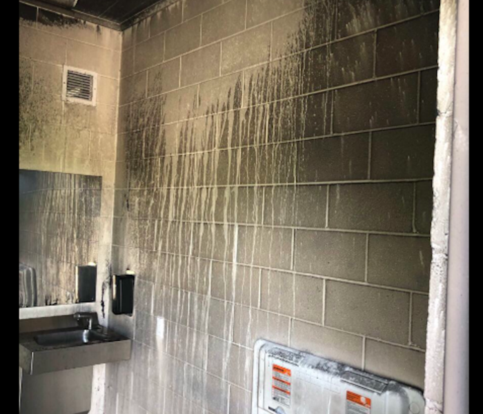 Soot stained walls in a public bathroom. 